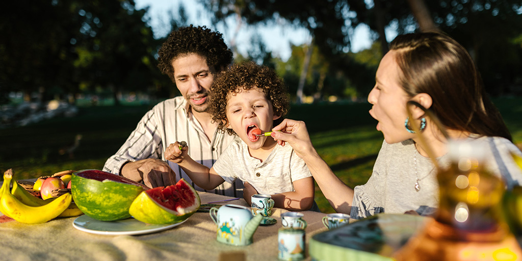 Dad and two children outside on grass